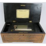 An antique Swiss music box in burr walnut and ebonised case. Steel and brass mechanism with steel