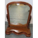 A Victorian walnut swing vanity mirror with shaped uprights and serpentine plinth base, on