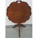 A Georgian mahogany piecrust tilt-top occasional table, on a wrythen carved column with tripod base.