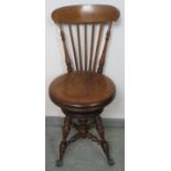 A Victorian walnut cellist’s seat with spindle backrest and height adjustable seat, on turned