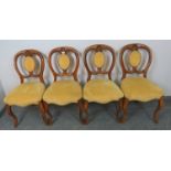 A set of four Victorian walnut balloon back dining chairs, with shell carved backrests,