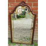 An Edwardian wall mirror with carved shell cornice in a parcel gilt oak frame with pierced tracery