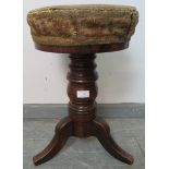 A Victorian mahogany height adjustable music stool, retaining the original tapestry seat and