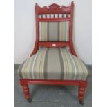 An Edwardian library chair, with carved cornice, raised on tapering turned supports with ceramic