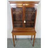 An Edwardian mahogany display cabinet on stand, strung with satinwood and featuring coromandel