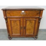 A Victorian burr walnut and mahogany side cabinet, featuring carved corbels, with one long frieze