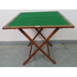 A late 19th century walnut campaign card table, with inset green baize, on a folding ‘X-frame’