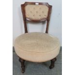 A late Victorian mahogany circular bedroom chair, upholstered in beige buttoned material, on