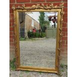 A large rectangular bevelled wall mirror in giltwood frame in the form of fruiting vines.