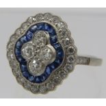 A platinum sapphire & diamond ring, four central diamonds surrounded by citrine cut sapphire. The