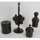 A four piece antique turned ebony gentleman's toilet set including stand with four containers, two