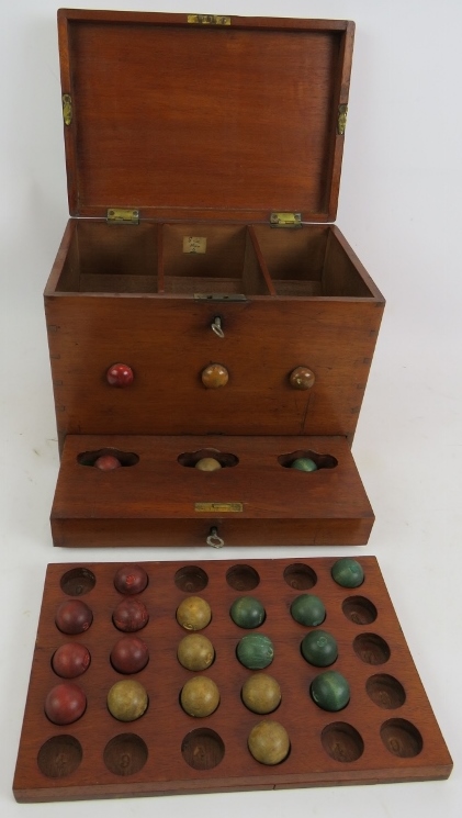 An antique lotto type ball game consisting of box, numbered board and wooden balls. 27cm x 21cm x