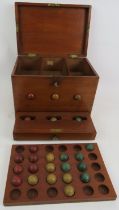 An antique lotto type ball game consisting of box, numbered board and wooden balls. 27cm x 21cm x