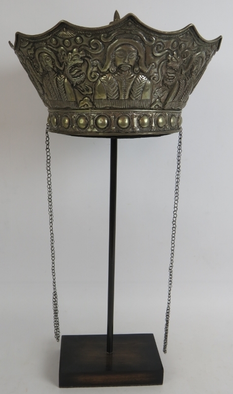 A Chinese white metal ceremonial crown shaped hat with phoenix and dragon repousse decoration.