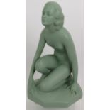 An Art Deco plaster figure of a crouching nude with green painted finish. Incised mark 522 UB.