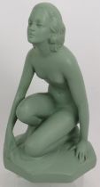 An Art Deco plaster figure of a crouching nude with green painted finish. Incised mark 522 UB.