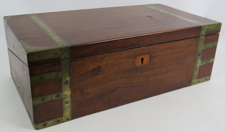 A Regency period mahogany writing slope, brass bound with interior fittings, secret drawers and a