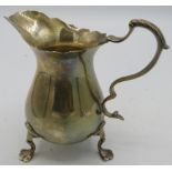 A silver cream jug with acanthus leaf handle and 3 cast trefoil feet. Approx: 31/2" high. Chester