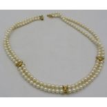 A double strand pearl necklace of uniform size, with 18ct yellow gold clasp and 3 18ct gold and