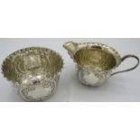 A silver matching cream jug and sugar bowl, engraved with scrolls and foliate design. Sheffield