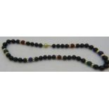 A black onyx, lapis lazuli and cornelian necklace with 14 yellow metal spacers and on a 9ct yellow