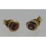 A pair of 14ct yellow gold stud earrings set with pink tourmaline. Approx: weight 1.6grams. Boxed.