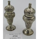 A pair of 19th century silver pepper pots. Embossed with 1/2 fluting and floral decoration.