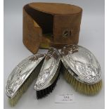 An unusual set of 3 silver back clothes brushes. Embossed with garlands of flowers Chester 1912. All