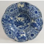 An antique Chinese Delft ware blue and white dish with segmented petalled rim. Diameter 26cm.