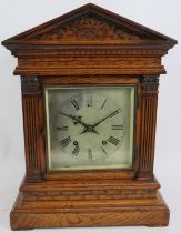 An Edwardian oak cased Palladian style mantel clock with striking movement. Pendulum present. No