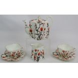 Wileman & Co (Foley) pre Shelley fluted teapot, jug and two cups and saucers decorated with flowers.