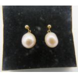 A pair of 9ct yellow gold droplet earrings with suspended pink peach pearls. Boxed. Condition