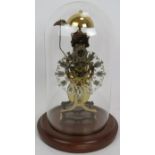 A contemporary brass skeleton clock with German striking movement under a glass dome. No key.