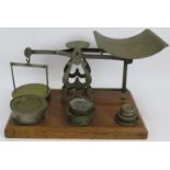 A set of vintage English 7lb parcel postal scales mounted on an oak stand with weights. Height 23cm.