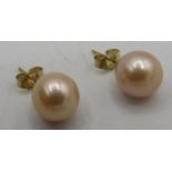 A pair of 9ct yellow gold round pink cultured pearl stud earrings. 2.6 grams. Condition report: Good