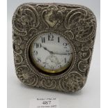 A silver cased pocket watch holder, indistinct hallmarks, embossed with scrolls & foliate