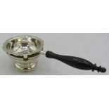 A modern silver tea strainer with base. The tea strainer has a wooden handle, London 2003, J.A