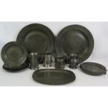 Two large antique pewter chargers, eight small plates, a plate warmer, an ovoid dish engraved
