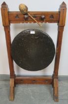 A 19th century Gothic Revival bronze dinner gong, suspended in an oak frame featuring trefoil carved