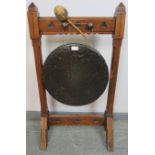A 19th century Gothic Revival bronze dinner gong, suspended in an oak frame featuring trefoil carved