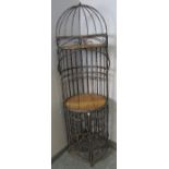 A vintage style wrought iron freestanding wine rack with cane bar area and shelf over, on bun