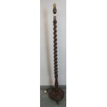 A vintage oak standard lamp with tapering barley twist and baluster turned column on a circular