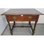 An 18th century oak side table, the single drawer fitted with brass swan neck handles, on turned and