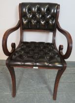 A reproduction mahogany desk chair in the Regency taste, upholstered in chocolate brown buttoned
