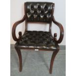 A reproduction mahogany desk chair in the Regency taste, upholstered in chocolate brown buttoned