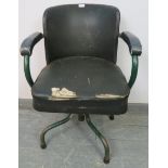A vintage machinist’s swivel armchair by Cox & co, upholstered in green Rexine, on steel supports.