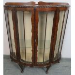 A 1920s mahogany demi-lune glazed display cabinet with gadrooned edge, on cabriole supports.