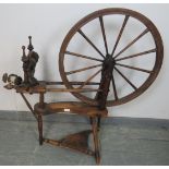 A 19th century oak and mahogany pedal driven flax spinning wheel with turned finials. Includes two