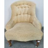 A Victorian nursing chair reupholstered in buttoned cream material, on tapering walnut supports with