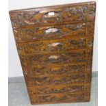A vintage style Chinese export chest of 8 long drawers with recessed handles, ornately carved with